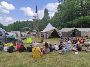 Akcja Bezpieczne Wakacje grupa dzieci siedzi na ziemi