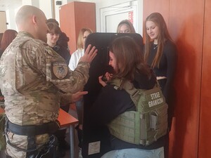 Uczniowie oglądają i przymierzają sprzęt służbowy SG 