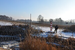 Funkcjonariusz SG przy granicy Funkcjonariusz SG stojący przy znaku granicznym przy polsko-białoruskiej granicy, w tle zaśnieżony krajobraz