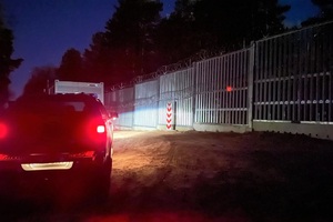 Granica nocą Tył pojazdu Straży Granicznej nocą, w tle bariera techniczna.