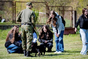 Spotkanie z funkcjonariuszami Straży Granicznej – Dzień otwarty Funkcjonariusz prezentuje umiejętności psa służbowego przed grupą młodzieży.