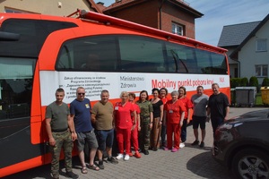 Akcja krwiodastwa w Rutce-Tartak grupa osób stoi przed autobusem centrum krwiodastwa