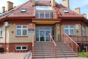 Widok od frontu. Schody z poręczami prowadzące do głównego wejścia.